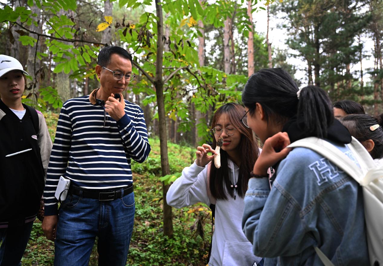 王占斌老師給同學(xué)們講解辨識(shí)蘑菇。（學(xué)校供圖）.jpg