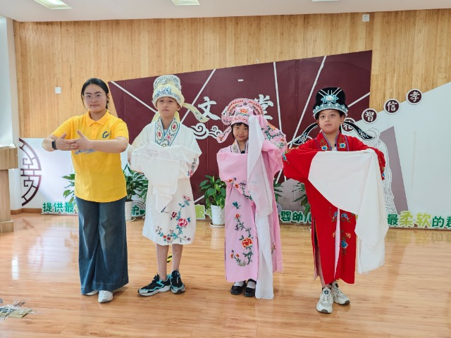 寧波職業(yè)技術(shù)大學“拾夢非遺”服務隊教小朋友們學唱傳統(tǒng)戲曲 學校供圖.jpg